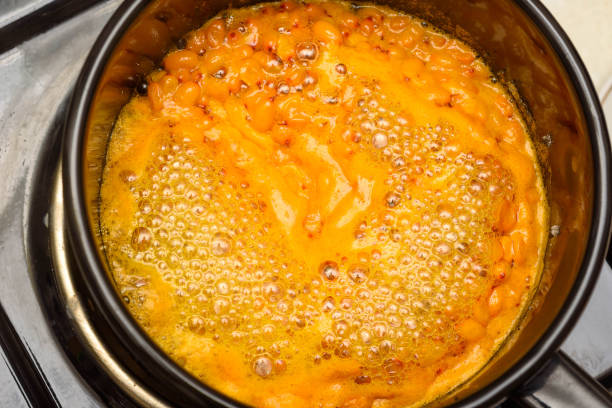 istock Boiling sea buckthorn berries with sugar in a saucepan for making jam. 2182990719