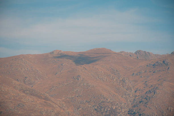 A rocky outcrop in the mountains of Corsica at Lama with the Cinto Massif and snow capped Monte Padru in the distance