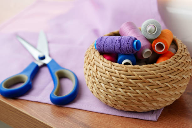 istock A woven basket filled with colorful sewing threads on a wooden table 2182992097