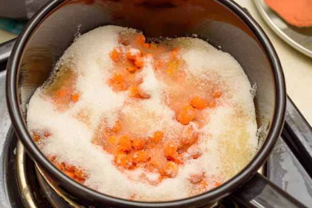 istock Sea buckthorn berries sprinkled with sugar in a saucepan for making jam. 2182992191