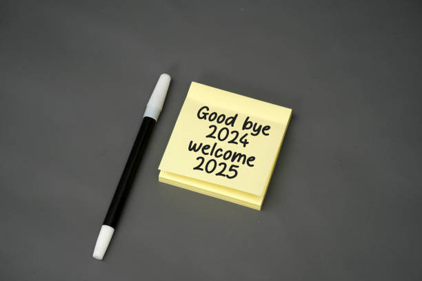 istock stick note with handwritten text goodbye 2024 and welcome 2025 with a pen on a black background 2182992231