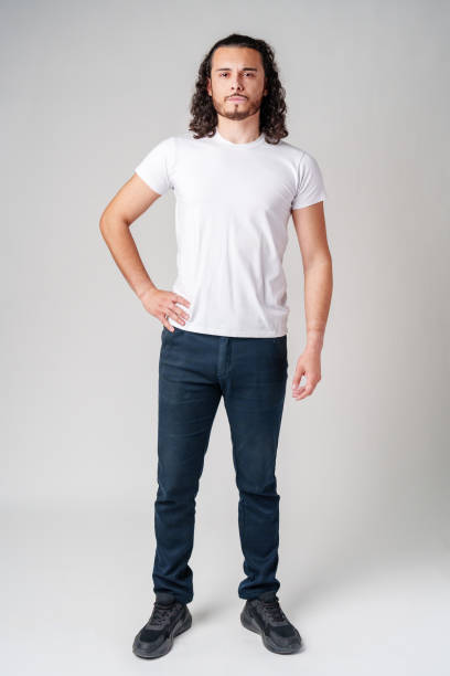 istock A young man with curly hair stands confidently against a neutral background 2182992985