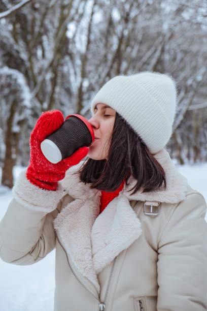 istock happy woman with coffee cup outdoors at winter cold day 2182993989