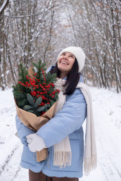istock Person Holding Bouquet on Snowy Forest Path 2182994009