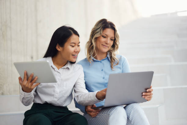 istock Happy female entrepreneurs working on wireless technology in a hallway. 2182996190