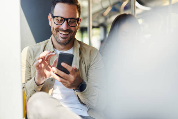 istock Happy man using mobile phone in a public transportation. 2182997090