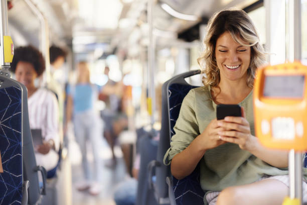 istock Happy woman using mobile phone in a public transport. 2182997571