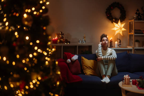 istock Pensive young woman sitting on sofa during christmas holidays 2182998977