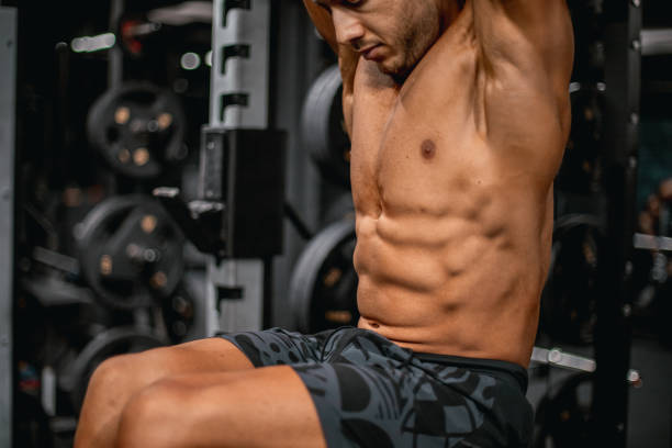 istock Muscular build athlete doing abs in a gym. Hanging Leg Raise 2182999544