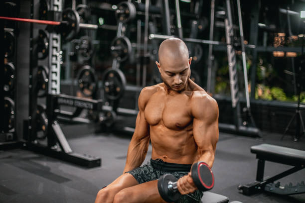 istock Strong and young bodybuilder during his workout in the gym. Biceps exercise 2182999826