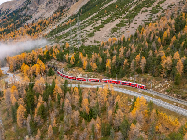 istock Red Train Winding Through Autumnal Mountain Scenery 2182999853