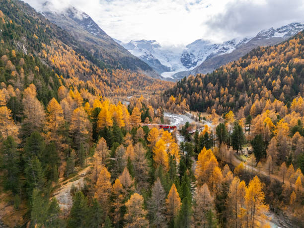 istock Scenic Red Train in Autumn Valley with Snow-Capped Peaks 2183000074