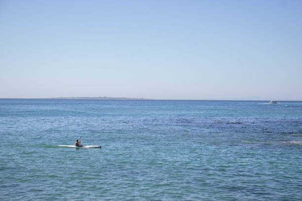 10.30.2024, Cape Town, South Africa; A single man kayaking on the Atlantic Ocean on a clear sky summer day on the South African Coast