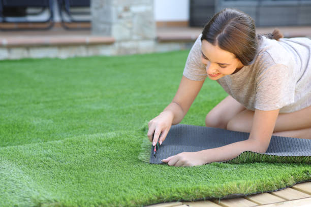 istock Happy woman installing artificial grass at home 2183009598