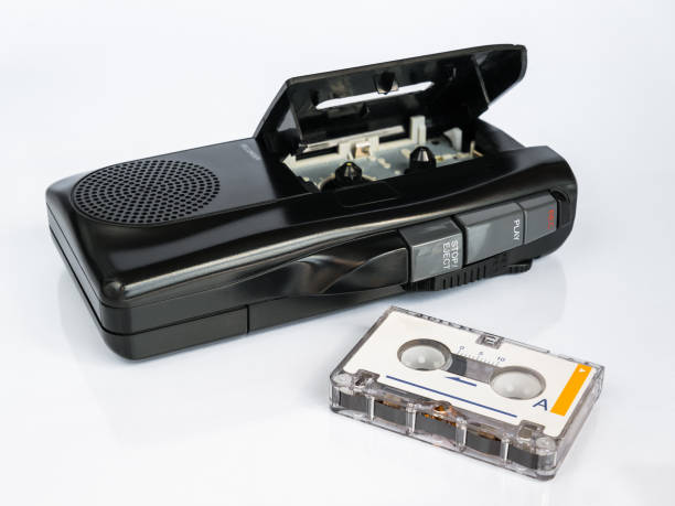 istock Audio micro cassette recorder and micro cassette tape in foreground, isolated 2183010198