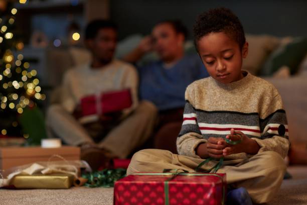 istock Cute Black Child Opening Christmas Gifts 2183012792