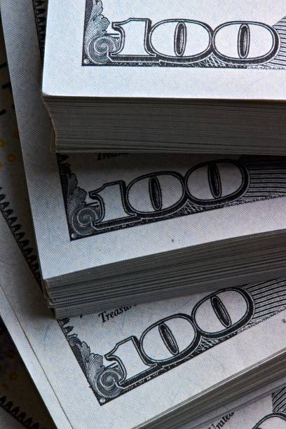 istock New US Dollar USD 2009 series bill bundles background for design. Many bundle of US 100 dollars bank notes vertical shot. 2183013219