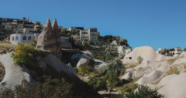 Discover Cappadocia's unique rock formations and ancient homes under a clear blue sky