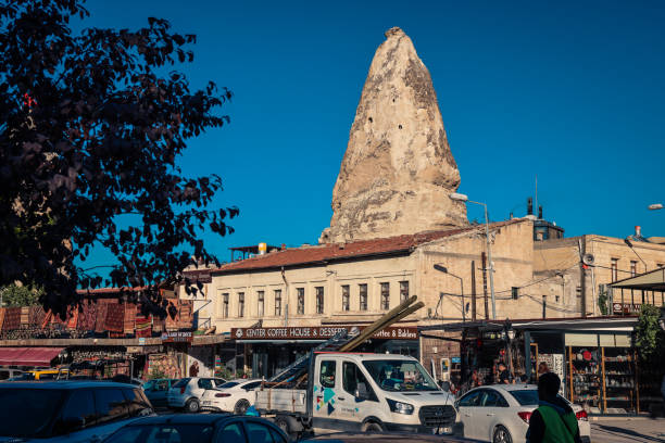 Cappadocia, Turkey - November 10, 2024: Visitors explore the lively streets of Cappadocia surrounded by striking rock formations under a clear blue sky. Local shops and cafes enhance the vibrant atmosphere of this historic area.