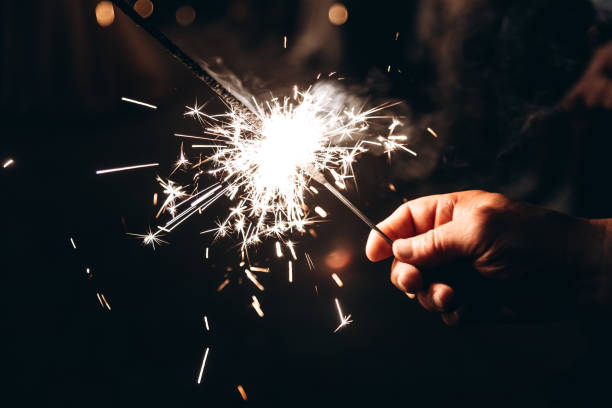 istock sparkling sparkler in man hand 2183017472