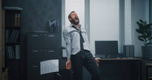 istock Furious office worker throws boxes and papers off the shelves, destroys office room, screams 2183018418