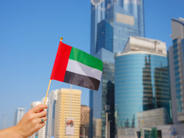 istock female hand holding tiny flag of UAE 2183021912