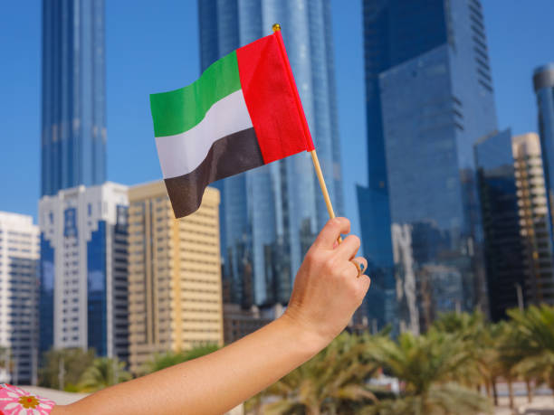 istock female hand holding tiny flag of UAE 2183021979