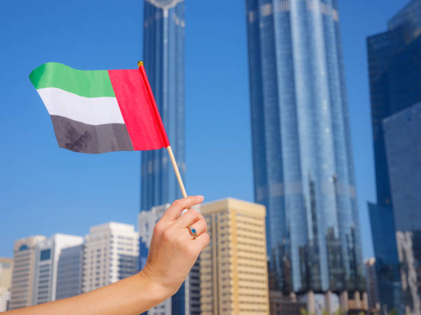 istock female hand holding tiny flag of UAE 2183022091