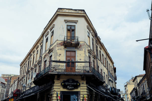 Bucharest, Romania - May 23, 2023: This location showcases an intriguing building with vintage features in Bucharest. The cloudy sky adds a moody atmosphere enhancing the historical charm of the area.
