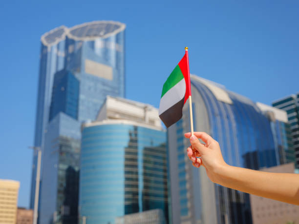 istock female hand holding tiny flag of UAE 2183023766