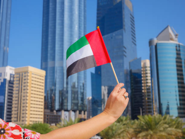 istock female hand holding tiny flag of UAE 2183023862