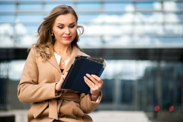 istock Businesswoman using digital tablet outside office building 2183024123