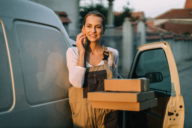 istock Woman talking on a phone and delivering packages in a white van 2183026965