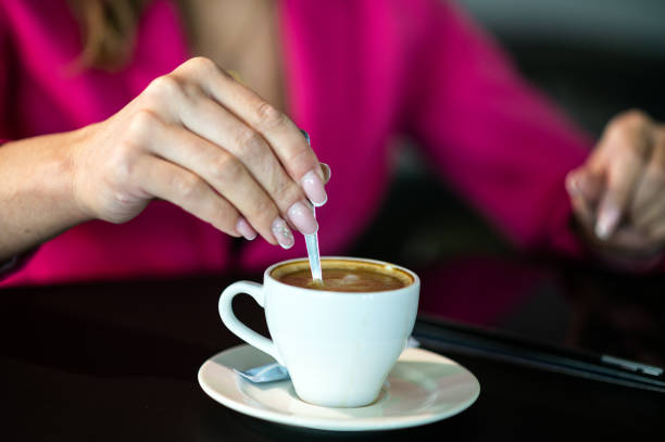 istock Businesswoman adding sugar to coffee during work break 2183027051
