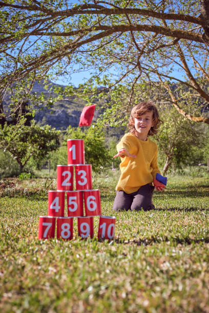 istock Little boy with knock down cans in park 2183030404