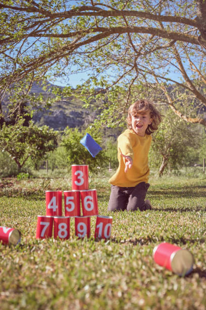 istock Cheerful kid playing can knockdown game in garden 2183030450