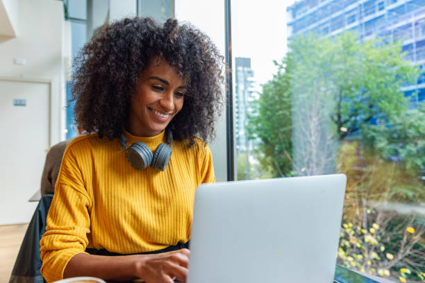 istock Young woman sitting in a caffe and working on her laptop 2183031744
