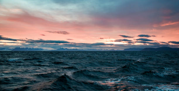 Twilight over the Arctic Ocean with rolling waves and vibrant sky hues in Svalbard