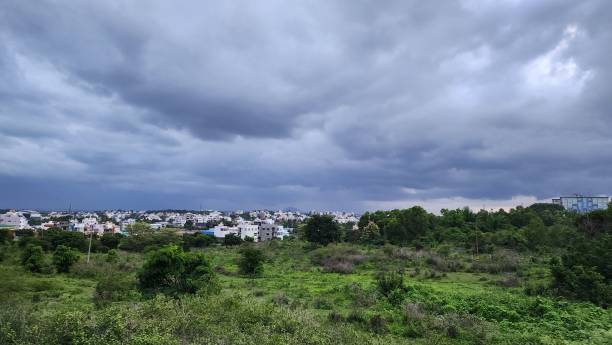 istock Panoramic view of a town surrounded by greenery under a cloudy sky. 2183040510