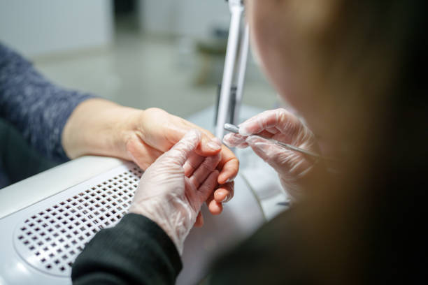 Senior woman with beautician for manicure.