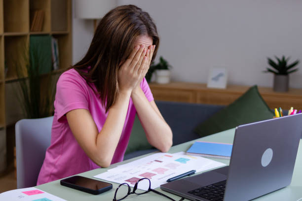 istock Stressed freelancer covering face with hands at home office desk 2183043404