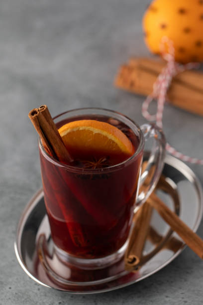 istock Hot mulled wine with cinnamon and orange slice on gray background, with spices. 2183045805