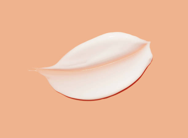 istock Cosmetic white cream balm mask texture smudge isolated on light orange background 2183047466
