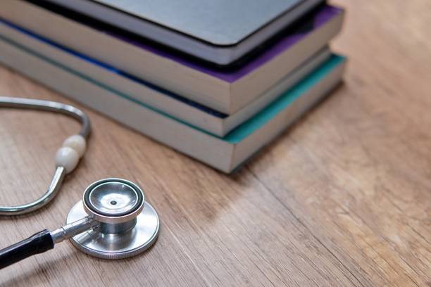 istock A stethoscope on a wooden table with a stack of textbooks. 2183049375