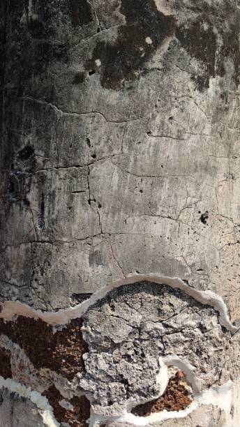 istock Close-up of textured concrete surface with cracks and peeling paint. 2183051517