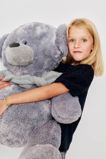 istock Beautiful little girl fun teddy bear joy on a light background 2183051525