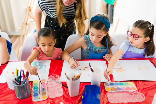 istock Group of elementary school students painting with watercolors and having fun during a creative art class with their teacher 2183054091