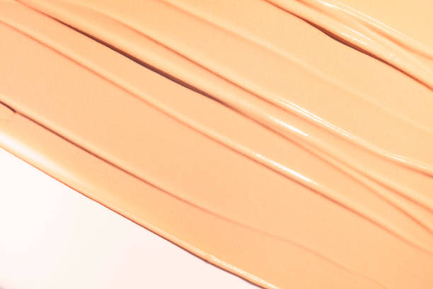istock Texture of smudge cosmetic bb or cc cream foundation, concealer with brush stick multicolored liquid green background 2183054868