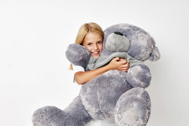 istock Beautiful little girl fun teddy bear joy on a light background 2183055595