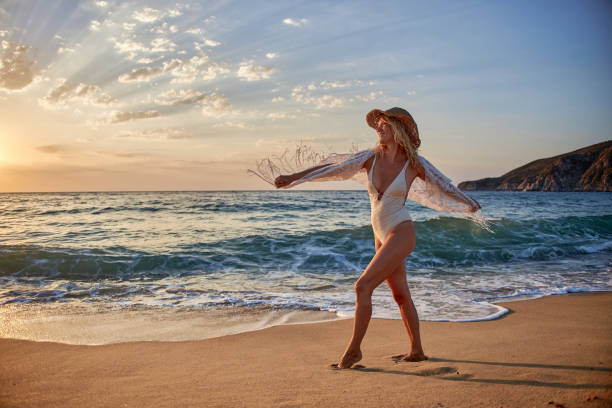 istock Beautiful woman running inside water on the beach at sunset 2183058241